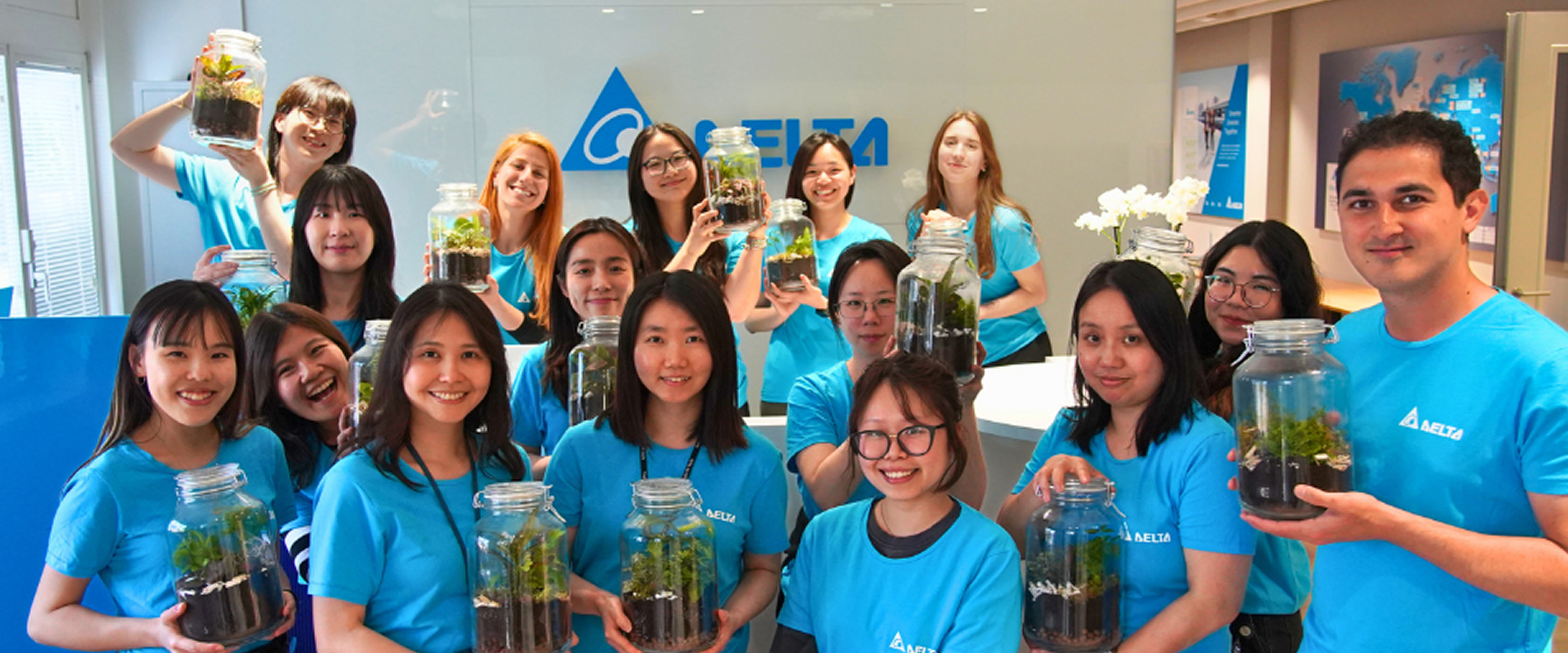 Delta team members holding terrarium jars at a sustainability event