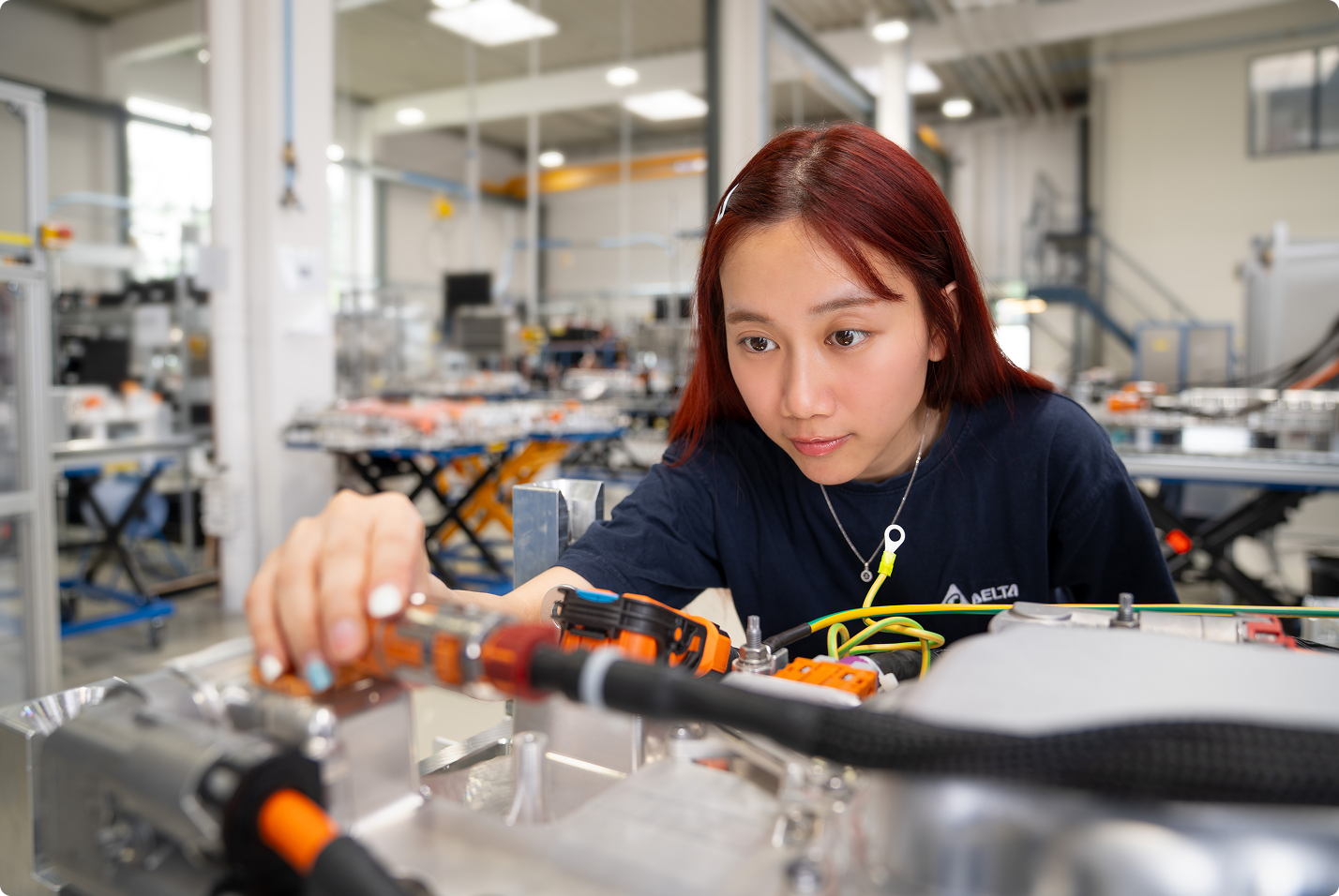 Delta employee working on power electronics in a manufacturing facility