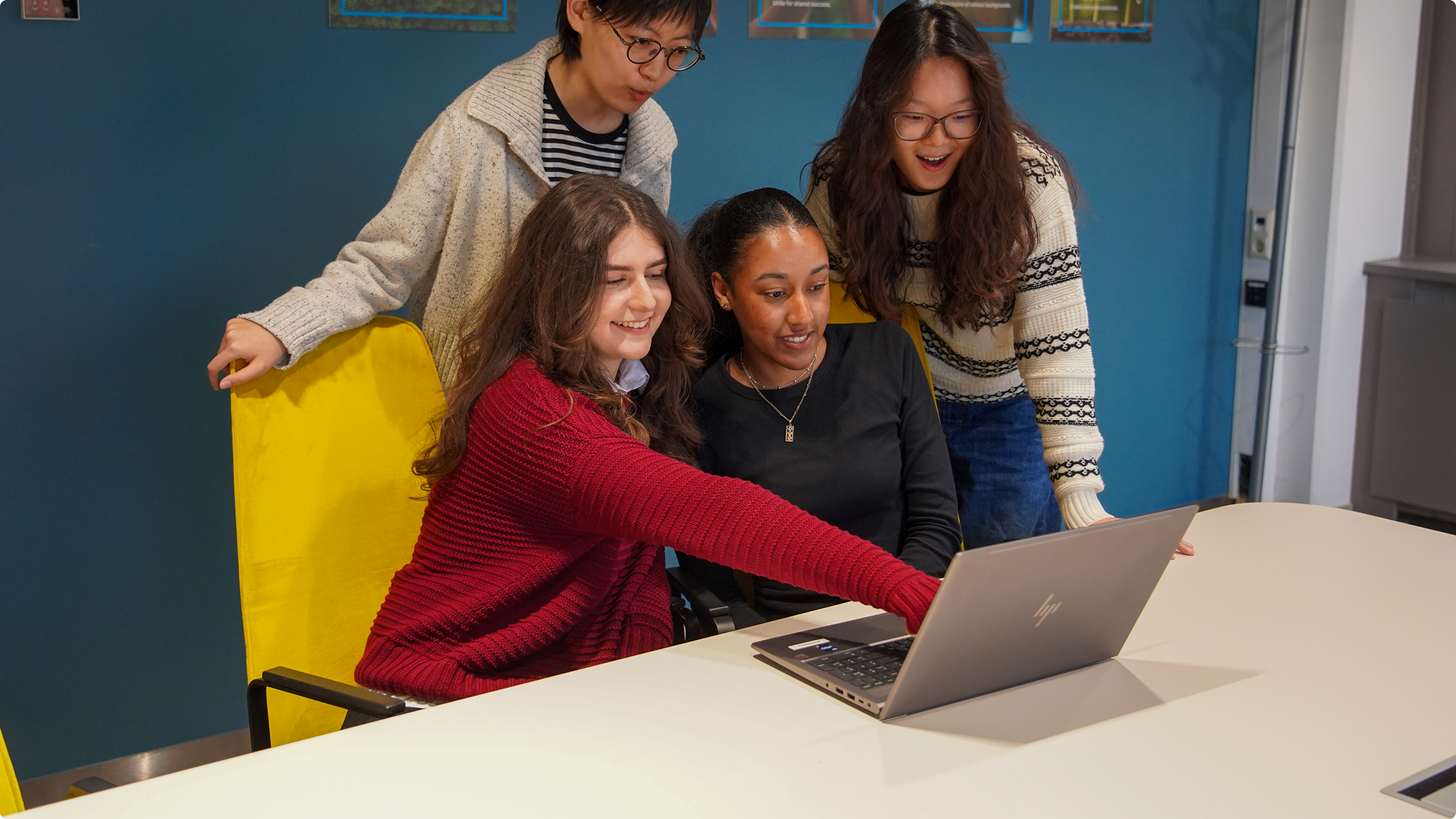 Delta interns collaborating around a laptop