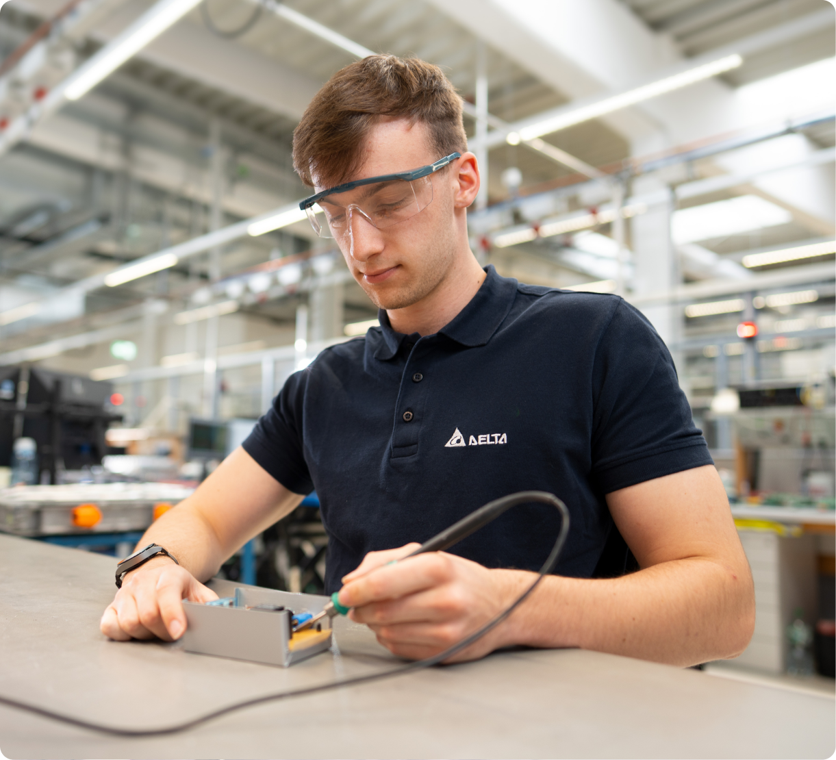 Delta employee soldering an electronic component in a lab