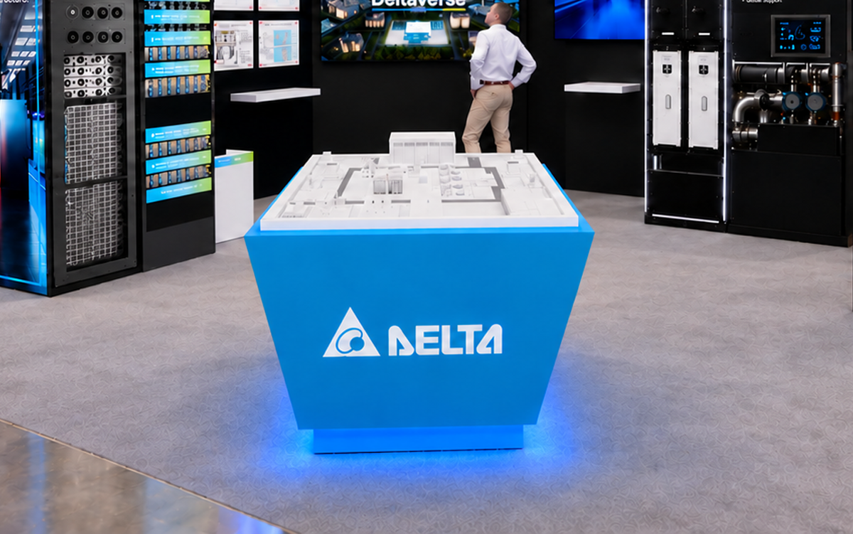 Delta booth at an industry exhibition featuring a blue central counter, digital displays, power systems, and visitors.